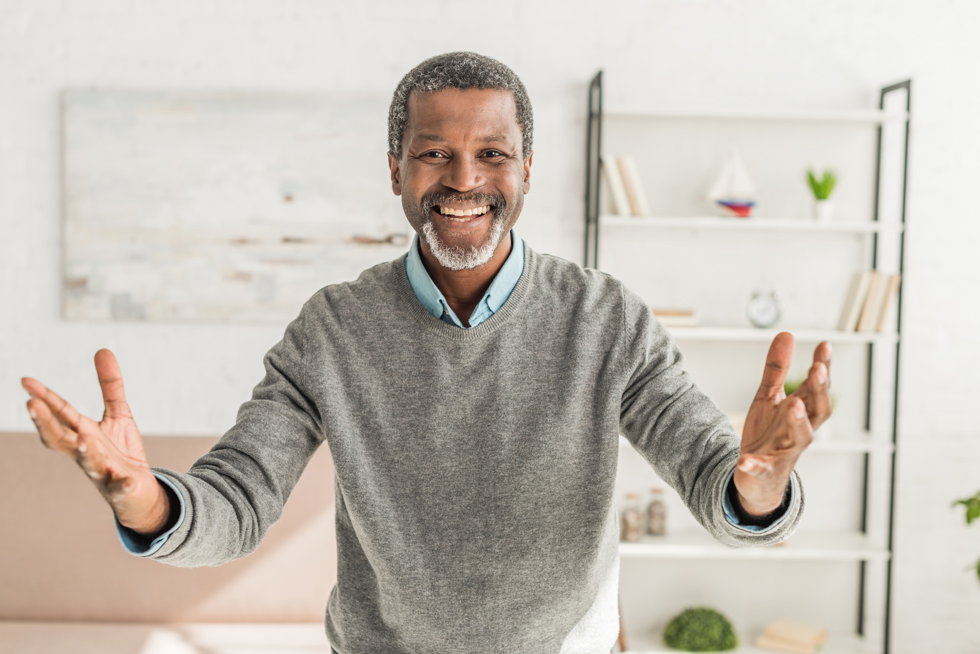 happy african american man looking at camera and showing welcome gesture